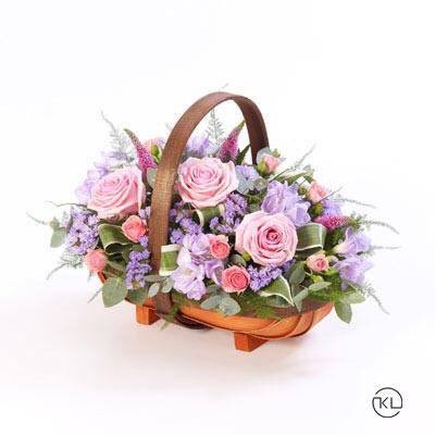 A traditional trug basket filled with roses, veronica, statice and scented freesias in pinks and lilacs. ow.ly/flST305NWjX