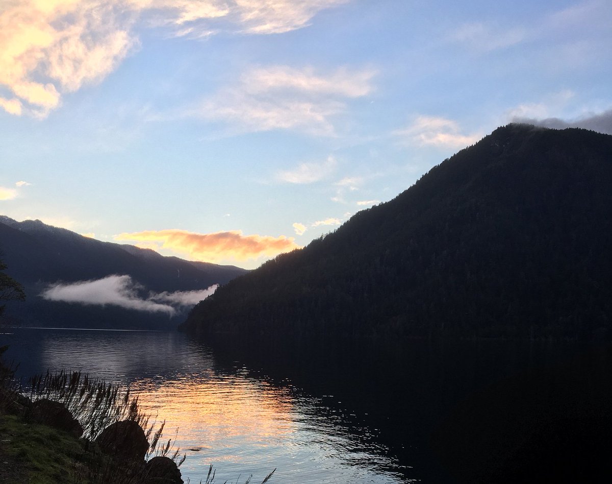 sunset with golden clouds and blue sky over a lake