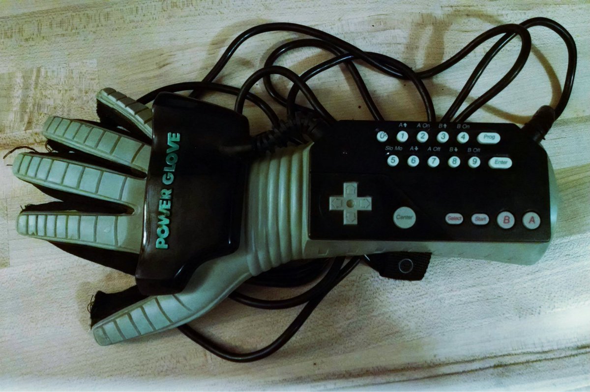 A vintage Power Glove game controller from Nintendo, sitting on a wooden table.