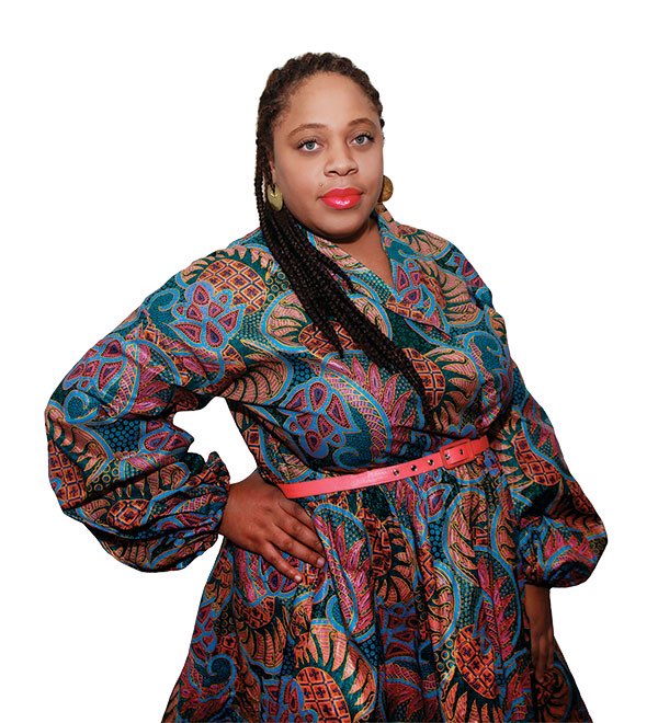 Elisheba Johnson poses against a white background in a colorful dress with a blue, red and orange pattern and a bright pink belt.