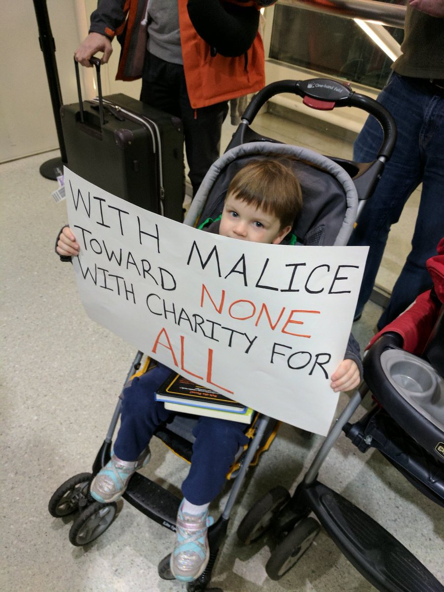 marissa_rae's tweet photo. Tonight at #bwiprotest at @BWI_Airport: my baby with my sign, plus my favorite local sign. https://t.co/XU7cVzGyBb