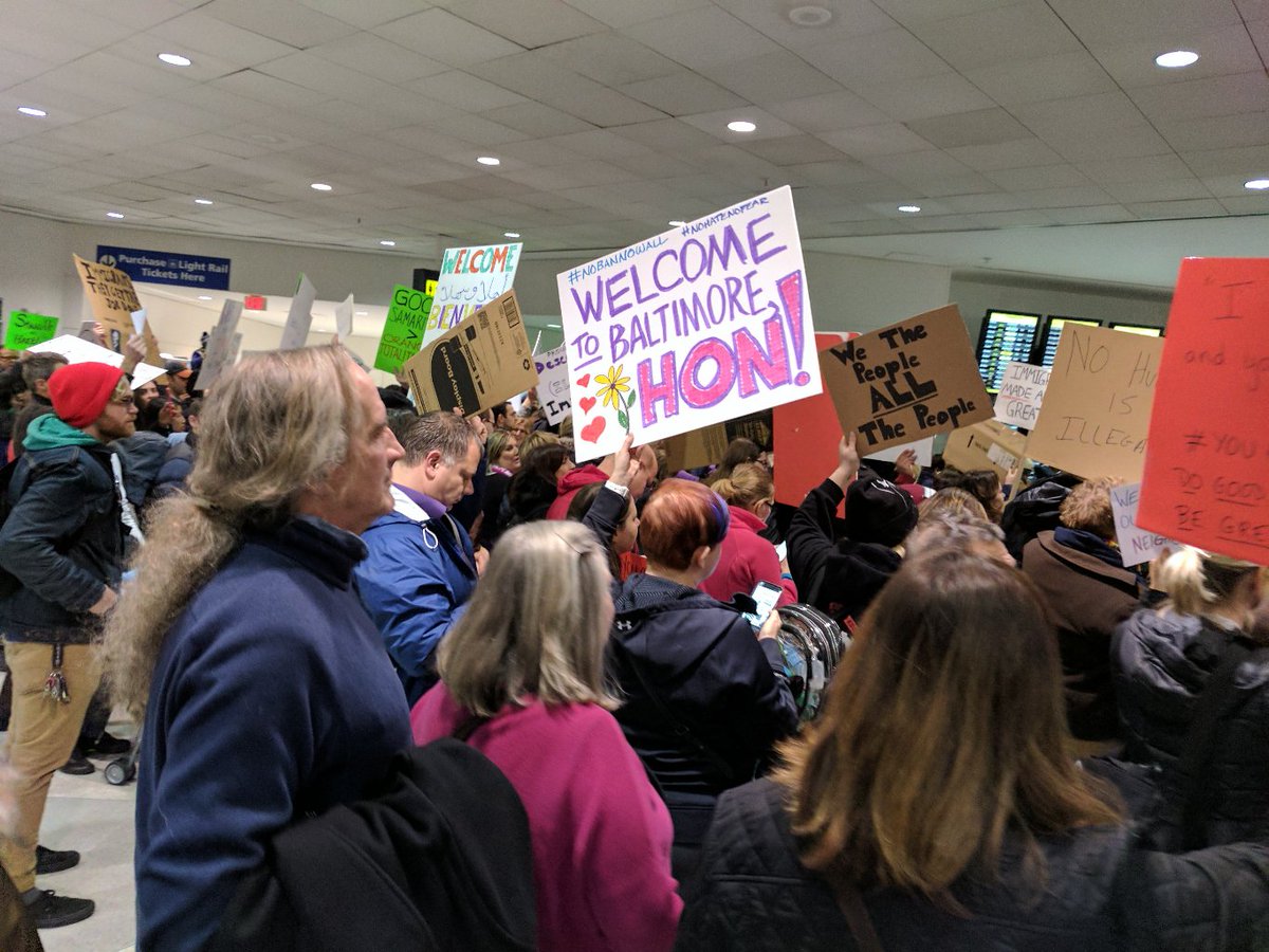 marissa_rae's tweet photo. Tonight at #bwiprotest at @BWI_Airport: my baby with my sign, plus my favorite local sign. https://t.co/XU7cVzGyBb