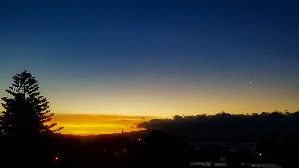 A Crescent new moon sets over whimsical clouds marching south into the summer sunset #metservicenz