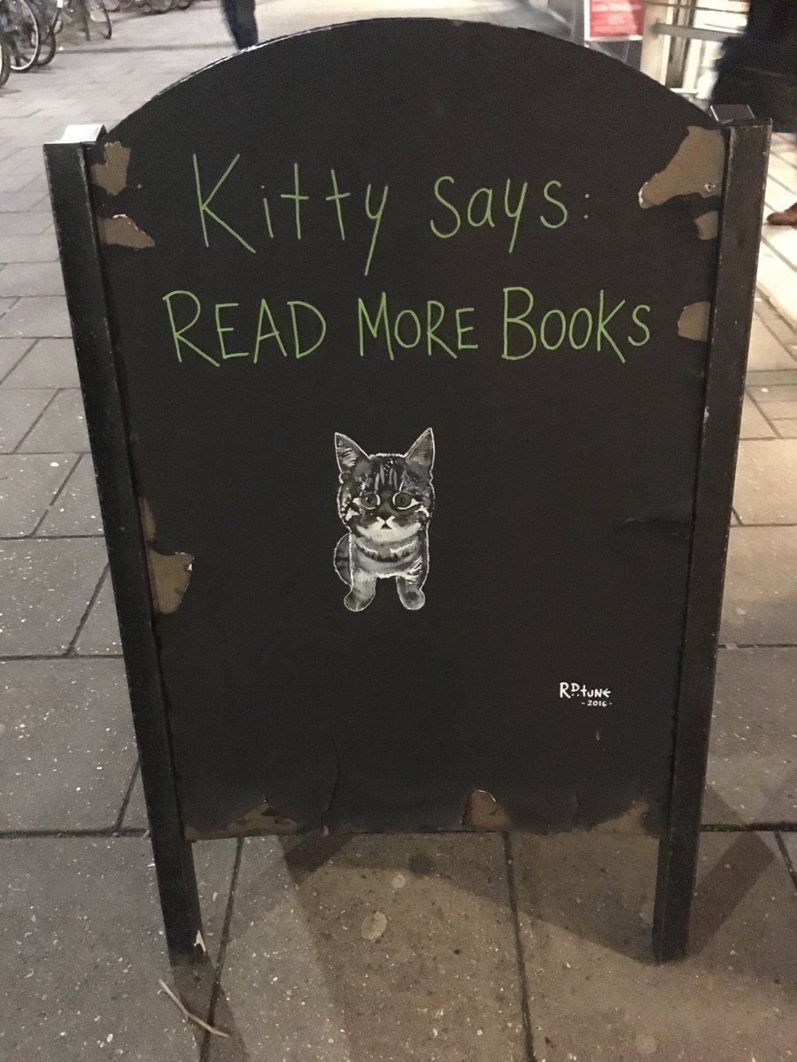 A sandwich board with a picture of a kitten and a caption "Kitty says: read more books"