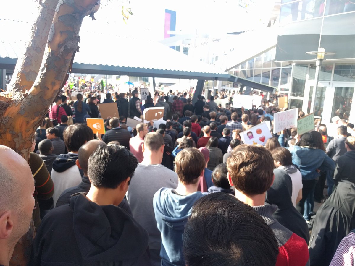A rally at the Google campus with protestors and stage setup for speakers