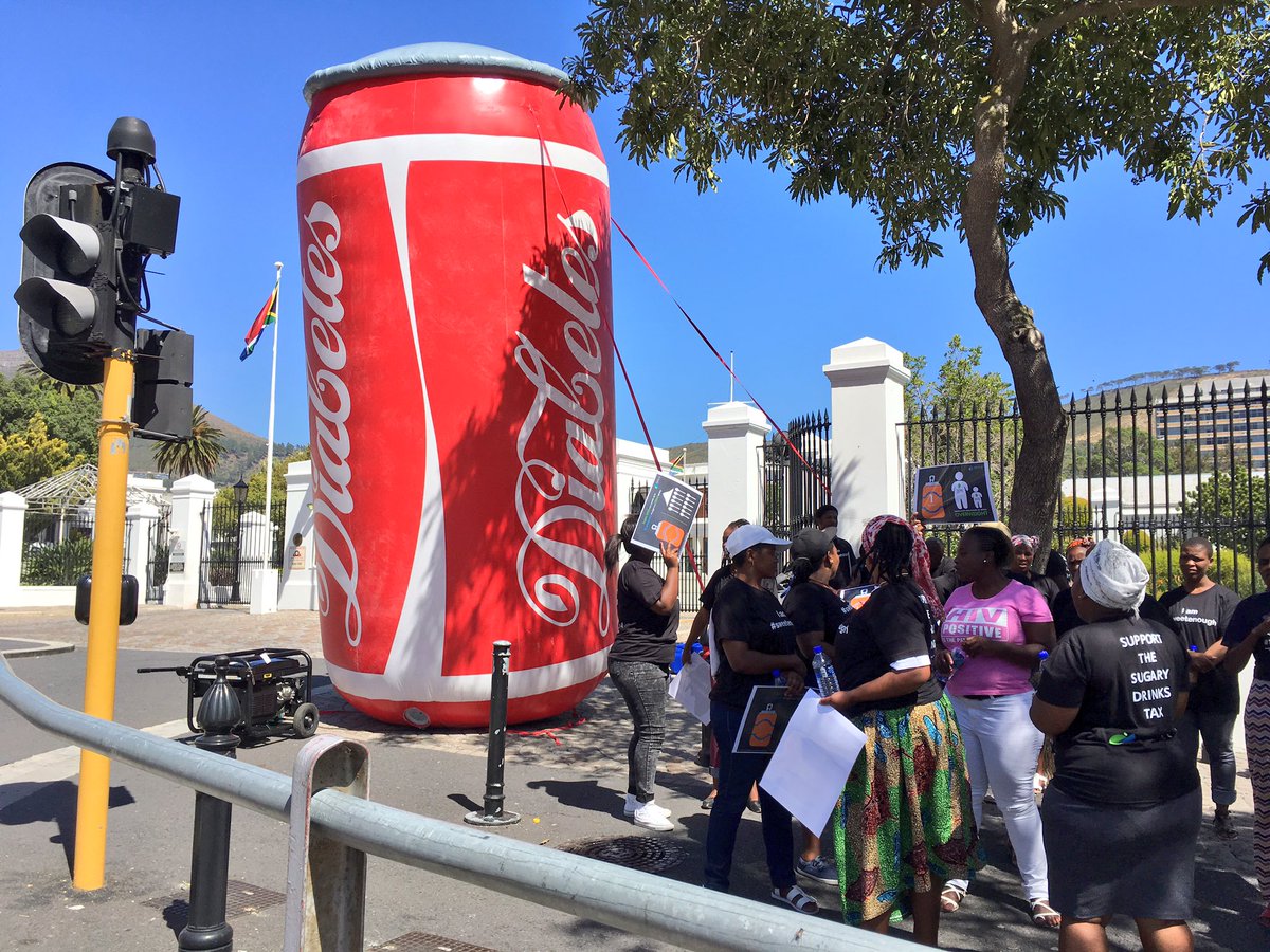 pheladi_s's tweet image. Small demonstration by some in favour of the #SugarTax in front of parly, inflatable Coke can reads "diabetes" #eNCA