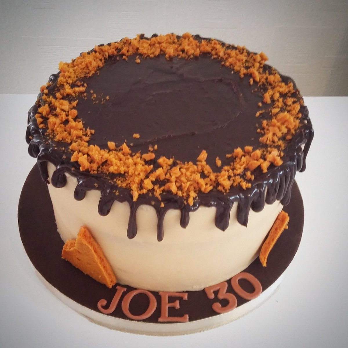 A salted caramel birthday cake with a chocolate ganache drip and homemade honeycomb.