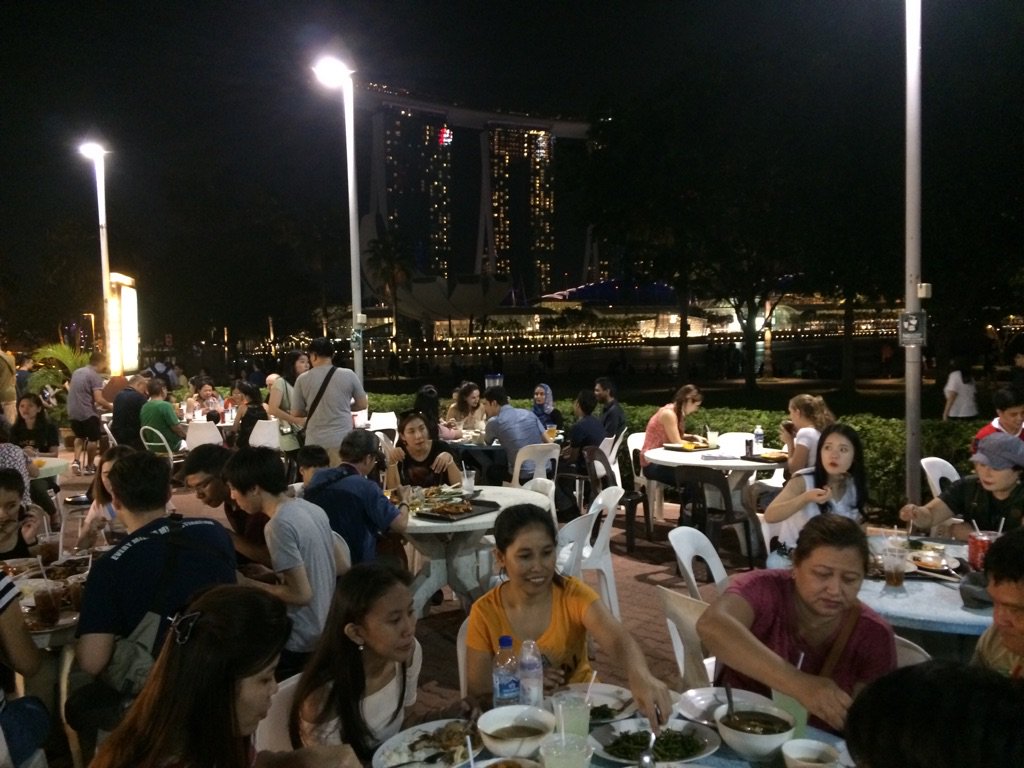 O Xrhsths 落語とローカルアジアから Sto Twitter 夜のシンガポールの屋外ホーカー 屋台街 を満喫している観光客たち 奥にライトアップされたベイサンズマリーナが見えます この国にきたら一度はホーカーを食べてみることをお勧めします 日本人好みのエスニックな
