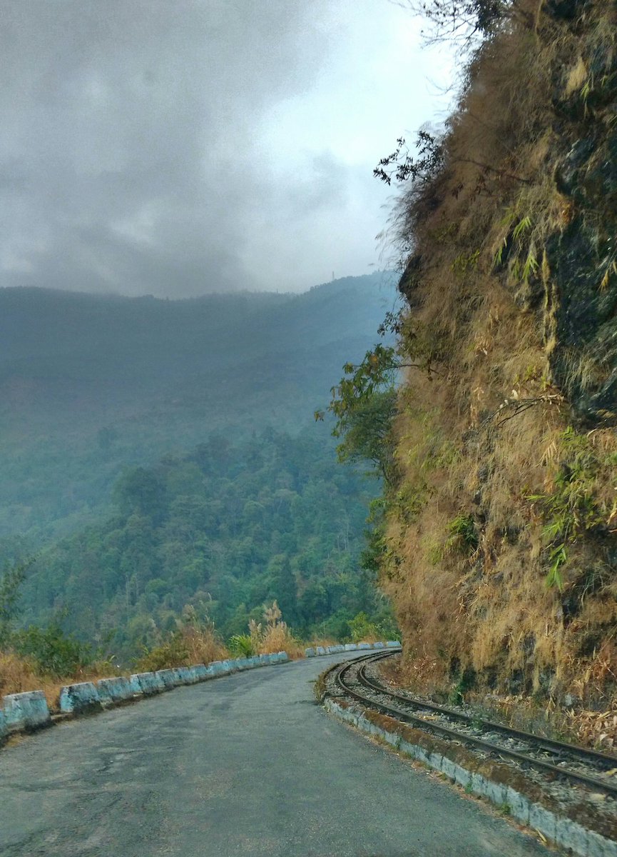 A rail and a road ran parallel in the mountains and I was confused.