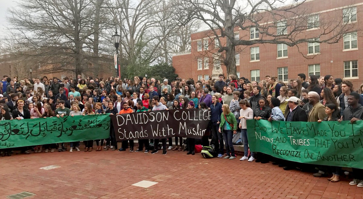 Crowd displaying "Davidson College Stands with Muslims" banners