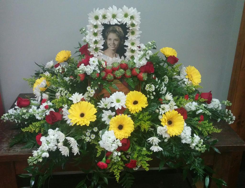 Tribute spray that was customized with basket filled with strawberries and flowers and frame decorated with daisies