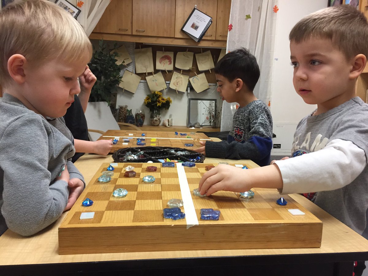 Playing 'follow the leader' symmetry with loose parts and recycled game boards. #STEM #math