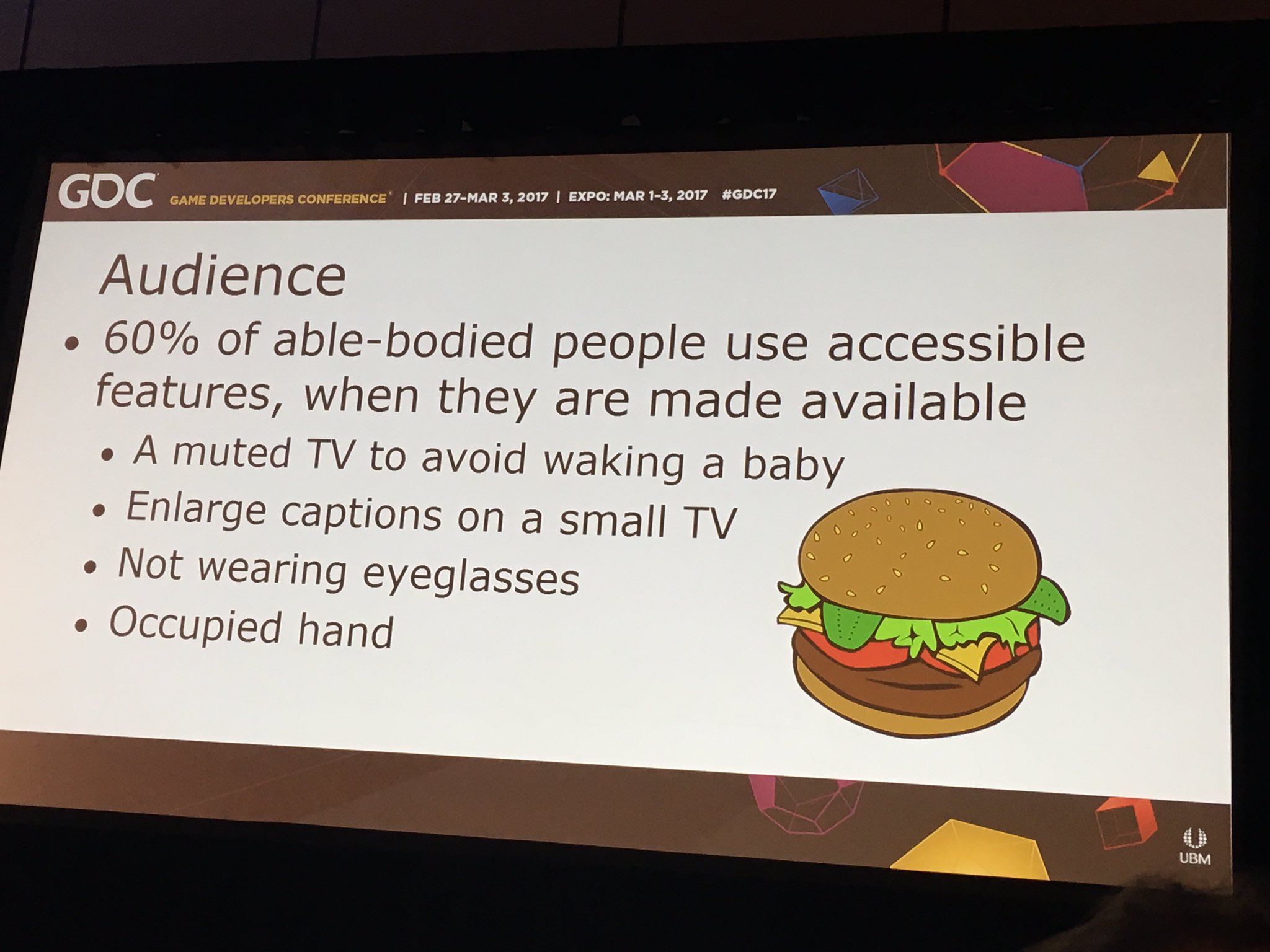 GDC slide that reads Audience: 60% of able-bodied people use accessibility features, when they are made available. A muted TV to avoid waking a baby. Enlarge captions on a small TV. Not wearing glasses. Occupied hand.