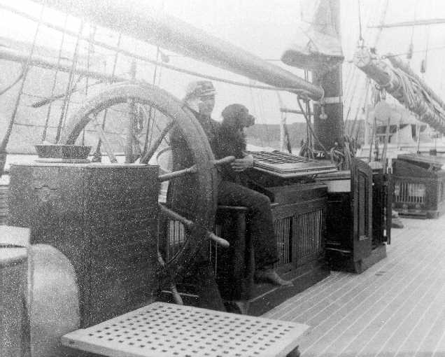 A black-and-white photograph of Captain Michael A. Healy on the deck of a ship with a dog by his side.
