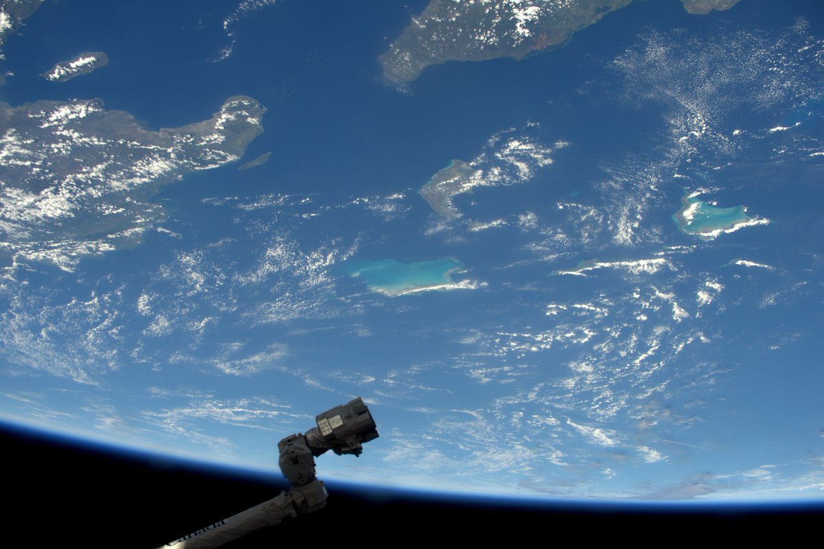 Thom_astro's tweet photo. The robotic arm spotted a beautiful island in the Caribbean. I’m sure he’d appreciate vacations, but there’s work to be done! #FridayIsland https://t.co/o1AujPxDqV