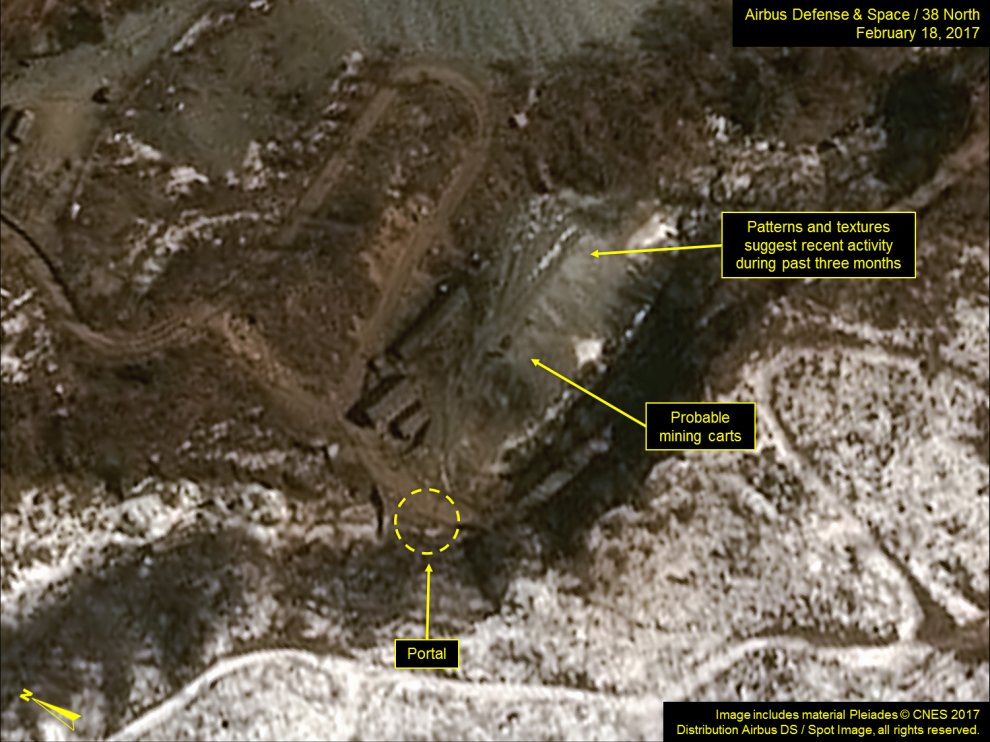 A commercial satellite image of North Korea's Punggye-ri nuclear test site shows an aerial view of brown earth, some snow, several buildings, and roads. The callouts say, "Patterns and textures suggest recent activity during past three months," "Probable mining carts," and "Portal."