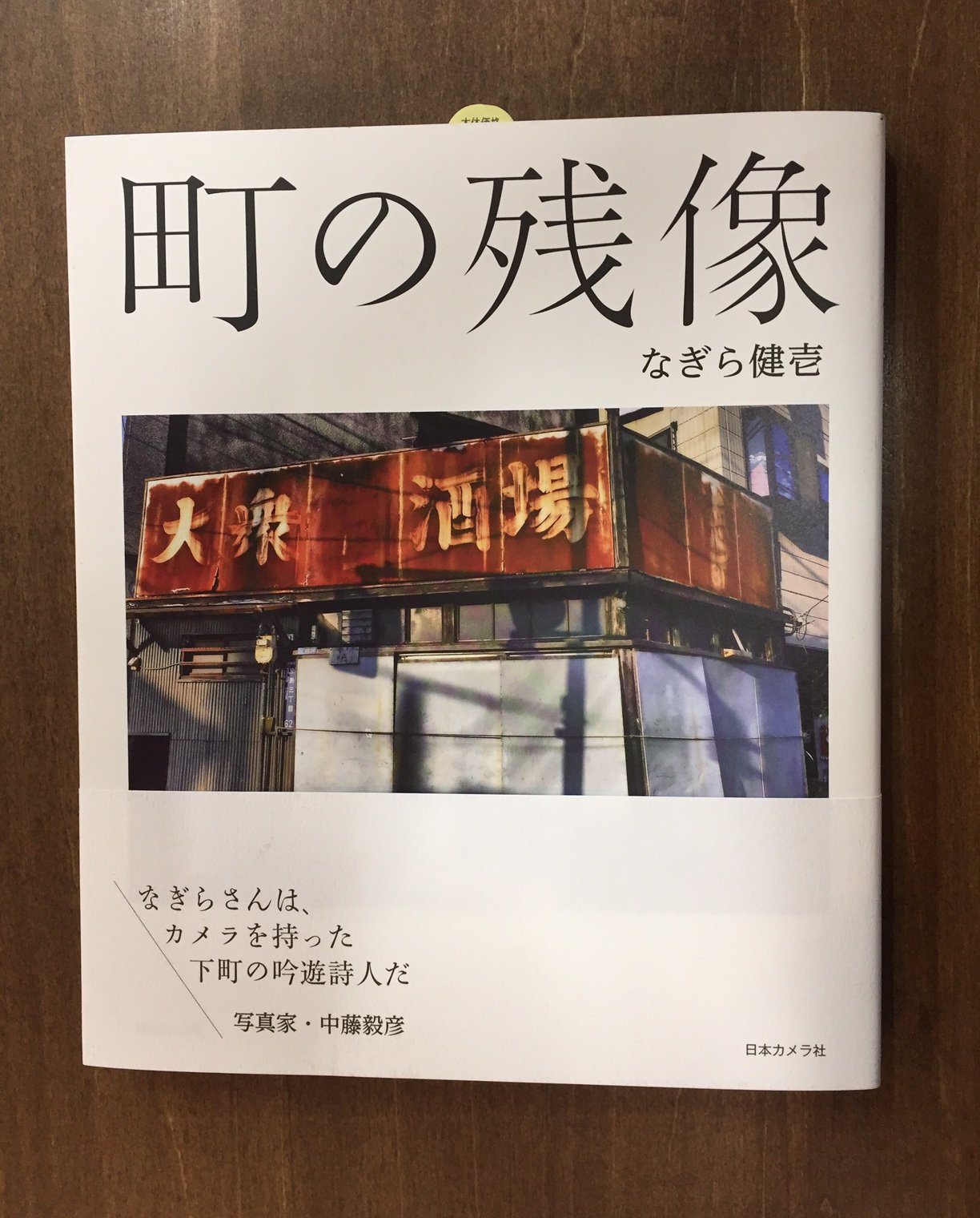 Title タイトル 町に残る痕跡をカメラ で拾い集め かってそこに存在した人の息吹を感じる 置き去りになってしまった風景には 時間と感情の積み重なりが色濃く残り それを見逃さずにシャッターをきるのが 今の詩人のつぶやき なぎら健壱 町の 残像