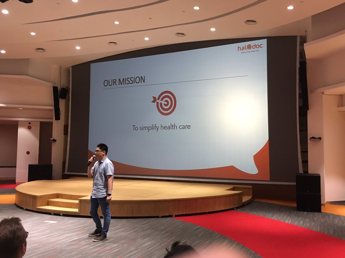 Alfons of <a href="/HaloDocID/">Halodoc Indonesia</a> on stage, explaining their experience in providing healthcare services on mobile