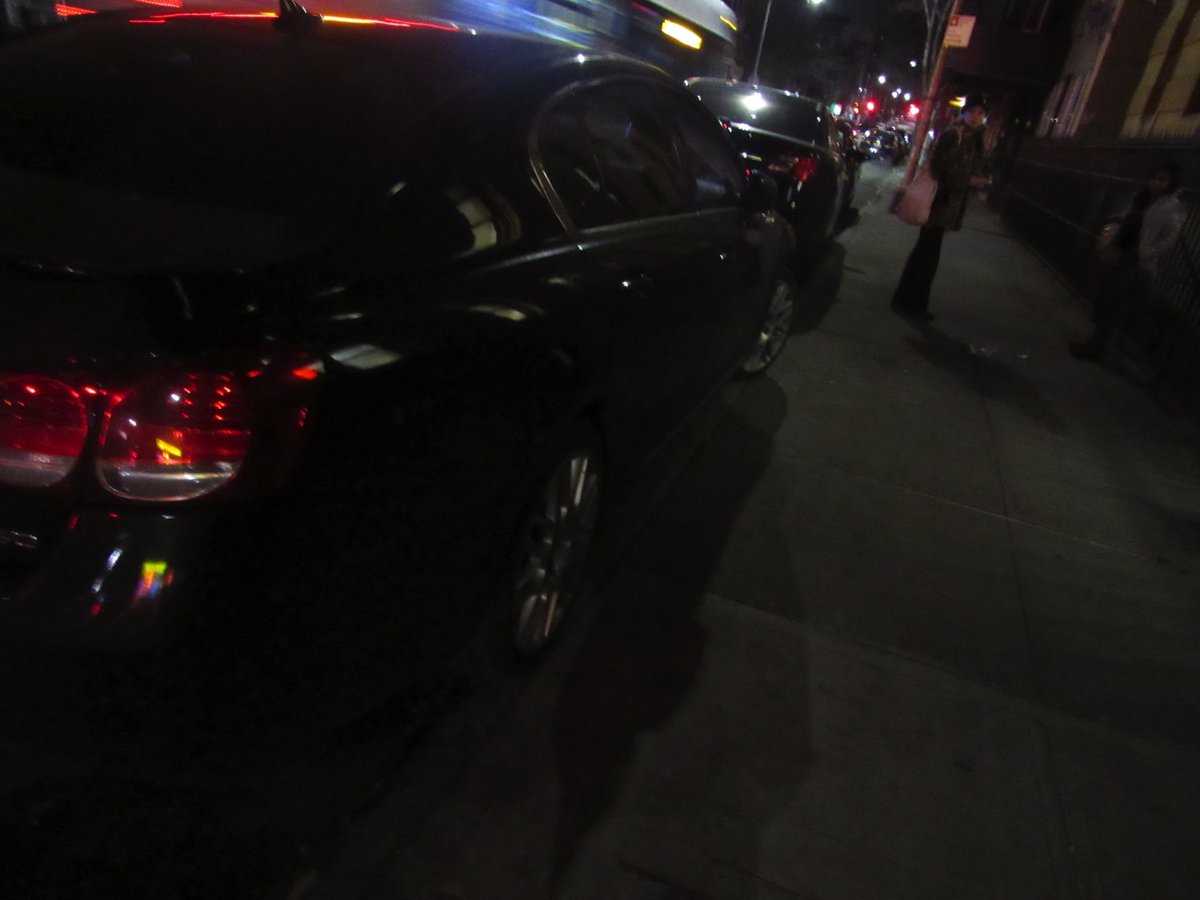 personal NYPD car inches on the sidewalk