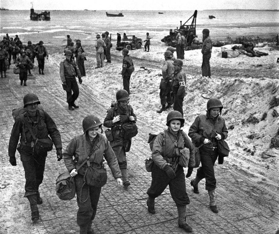AmericasMilHist's tweet photo. U.S. nurses walk along a beach in Normandy on July 4,1944, after wading through the surf from their landing craft to field hospitals. https://t.co/Oni3sKpE7U