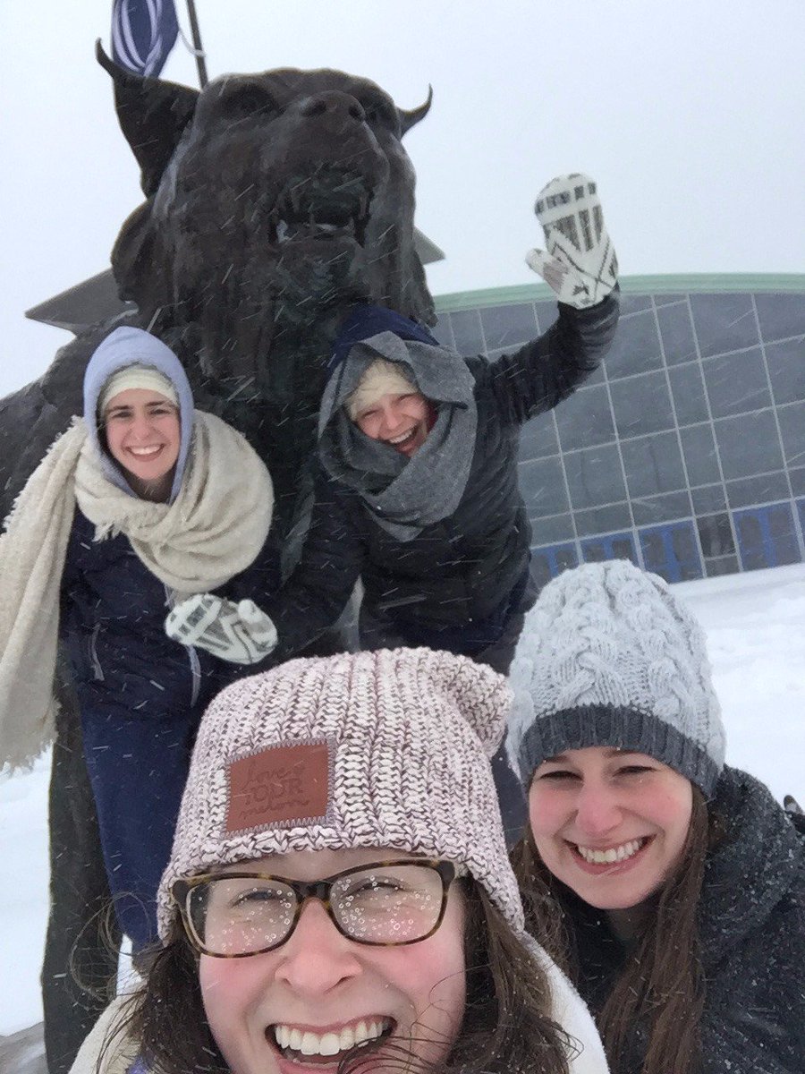 QuinnipiacU's tweet photo. A few grad students who stayed over spring break took a few minutes to celebrate the biggest snowstorm of the year with our York Hill bobcat https://t.co/jOiL4aVvbu