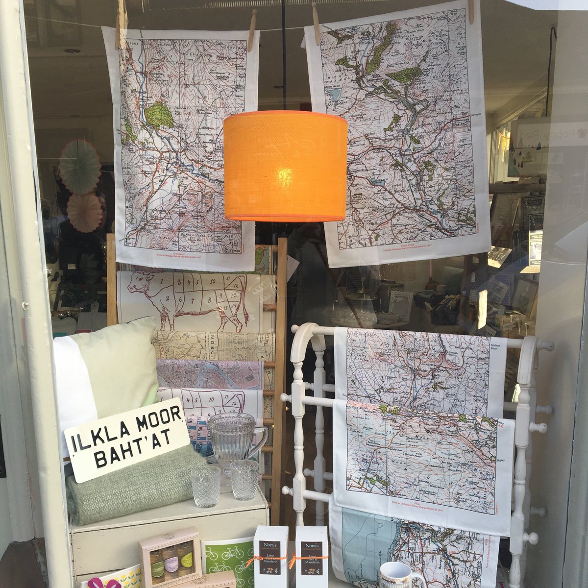 Got to love a <a href="/NorasIlkley/">Nora's - Ilkley</a> window display. She don't win prizes for nowt. #ilkley #shoplocal #bestdressed #lampshades #maps #teatowels