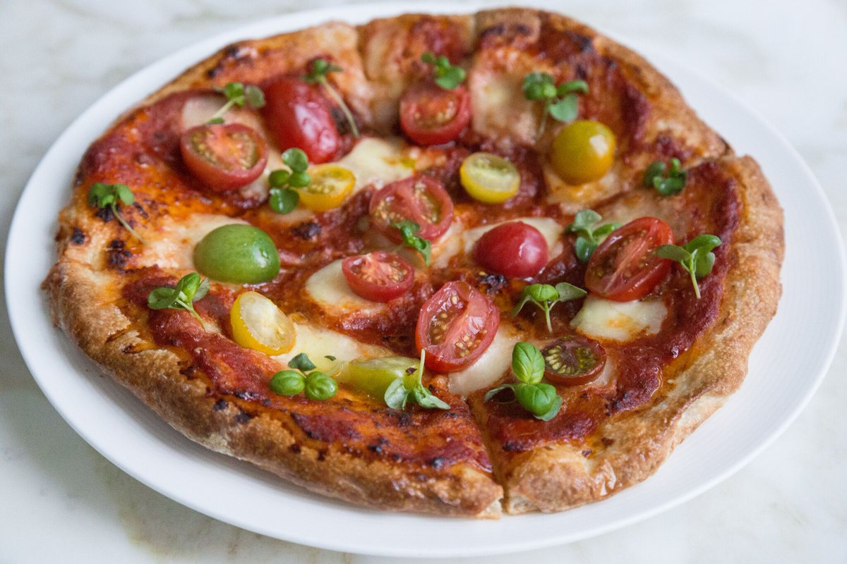 Being vegetarian doesn't mean sacrificing flavour when it's our Heirloom Tomato Pizza with Fresh Basil. ow.ly/zats309GHKG