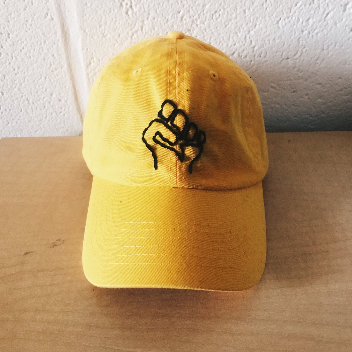 1MIBA's tweet photo. yellow hat // black string // black power fist
price: $25 https://t.co/M958SOFAiT