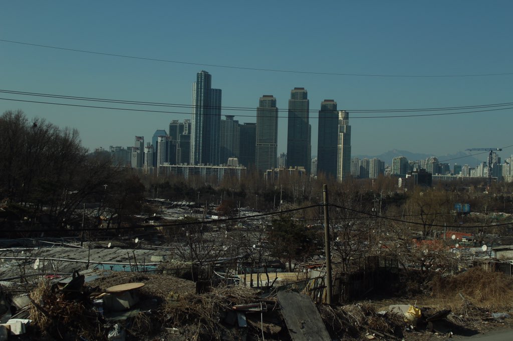 KsomeU's tweet image. ソウルはカンナムスタイルの聖地から目と鼻の先に九龍村というスラム街がある。そびえ立つ高層ビルを見て彼らは何を思うのだろう。高層ビルの上から地上に這い蹲くスラム街を見て、彼らは何を思うのだろう。僕たちに知る由はない。