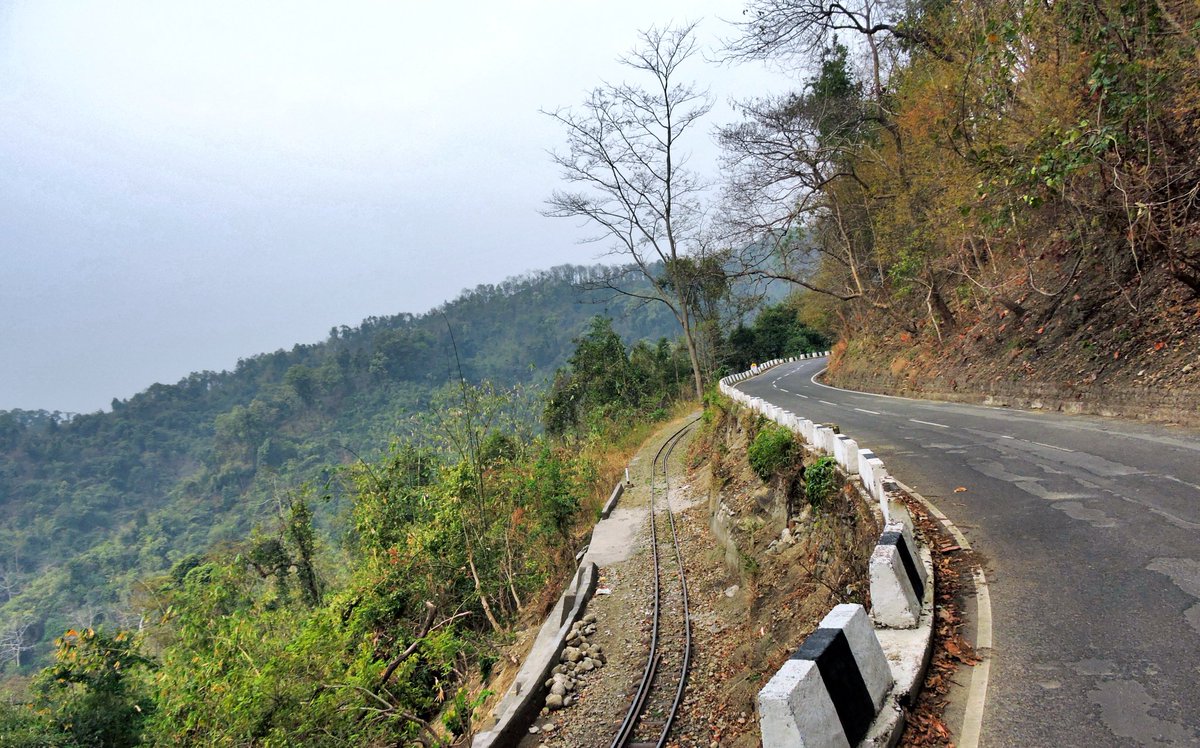 A rail and a road ran parallel along a cliff and I cannot wait for monsoon to arrive here!