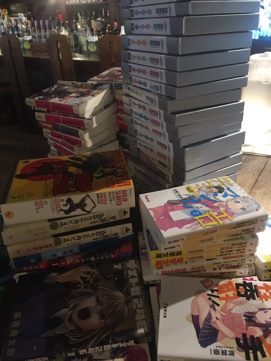 avindamono's tweet photo. とりあえず職場に持ってきてみたが、カウンターが蚤の市みたいになってる。控えめに言ってもラノベと漫画だけでまだ家に5倍ぐらいあるし持ってくるだけでしんどい。 https://t.co/vQ2MUrPmMt