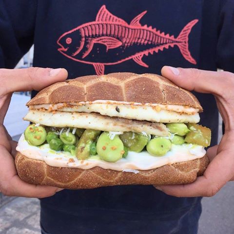 Panino ai cereali con orata al forno, granella di mandorle, emulsione al riccio di mare, insalata, fave, basilico e piselli, bufala!