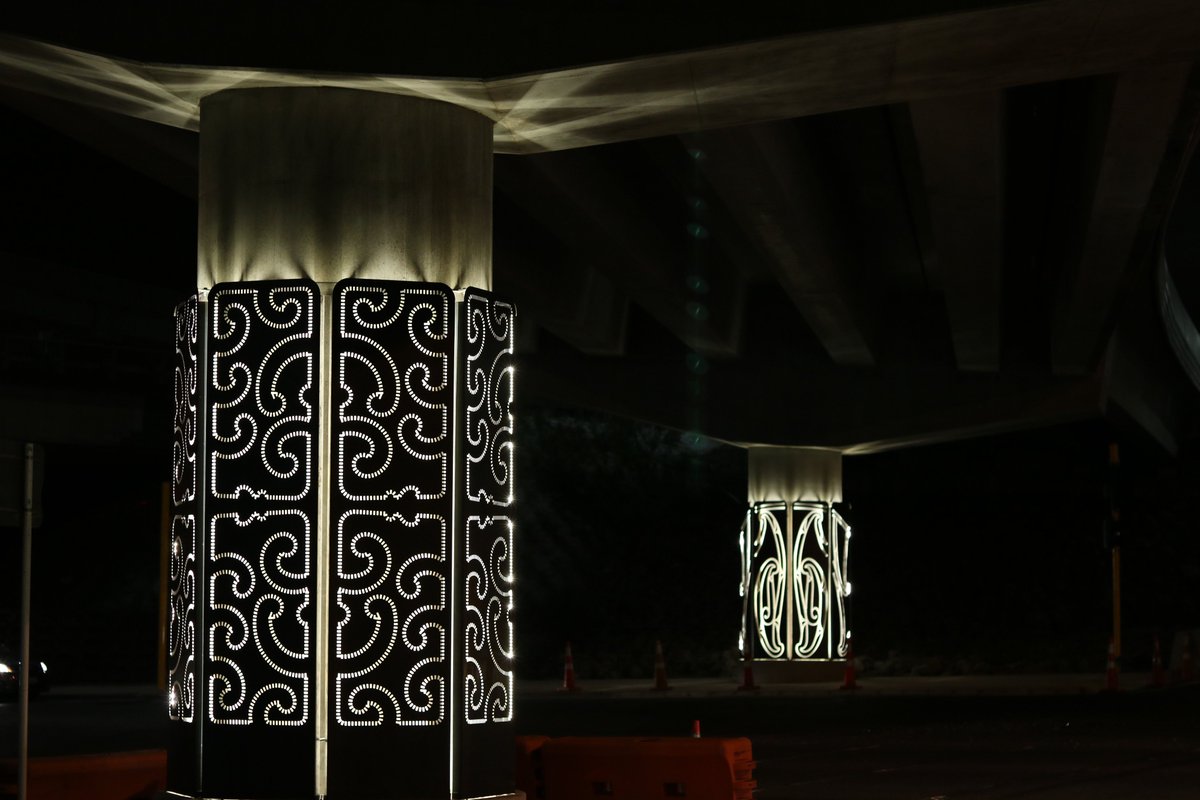 Waterview Connection pier artworks lit up beneath the motorway flyover at Great North Road.