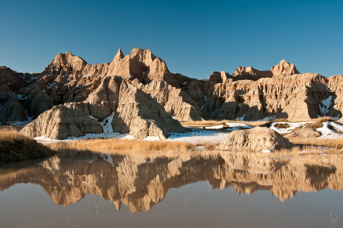 BadlandsNPS's tweet photo. Happy Monday, everyone. Enjoy this beautiful image of the #badlands formations reflected in puddles of melting snow. #findyourpark https://t.co/CPPxN9ShKN