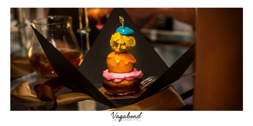 Trio of doughnut tower - base: strawberry cream, centre: jam, top: sugar glazed. Gift wrapped and served at a gallery opening.