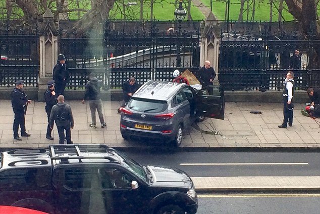 A car crashed into gates outside Parliament after mowing down up to a dozen people on Westminster Bridge causing carnage in the capital 