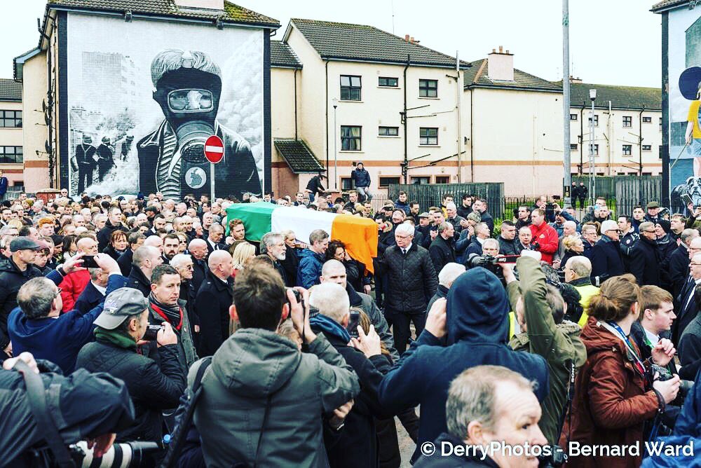 Martin McGuinness' coffin draped in the Irish Tri Colour as it passes the battle of the Bogside mural.  #martinmcguinness #funeral