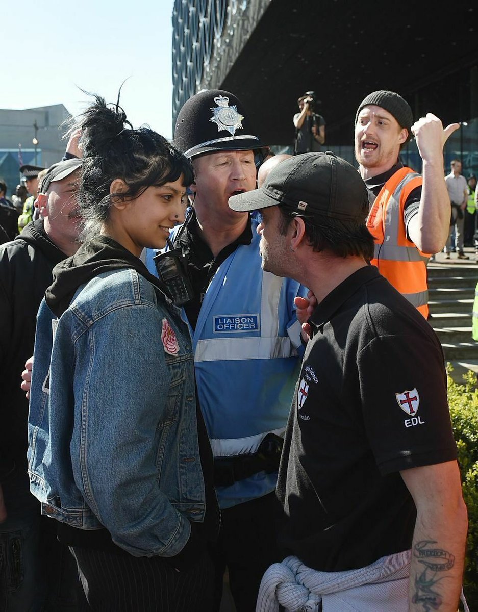 DrJoGrady's tweet photo. Iconic photo from @jjgiddens 

This is simply the most perfect response to EDL hatred; calm, somewhat nonchalant, defiant, and smiling. https://t.co/6gq3drBfER