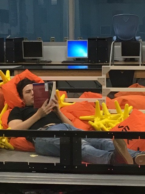retiredtitan's tweet photo. You just never know where you may find a senior reading his book for Reading Gala. Tomorrow is the BIG day, seniors!! @Yodas_minions https://t.co/kVtkCukUhh
