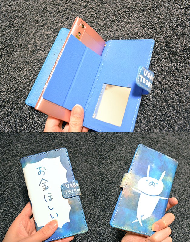 USAGI_TEIKOKU's tweet image. スマホカバーの内側はこんな感じです！右側の吸着面にスマホを貼り付ける仕様で、カードポケット、小型ミラー付き、カメラは写真のようにスマホを立てて使えます！明日から実際に使用感を確かめてみようと思いますので、街でこのケースを持っている人を見かけたら、遠くからそっと見守ってください！