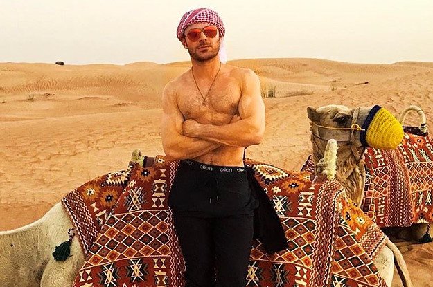 BuzzFeed's tweet photo. Zac Efron riding camels shirtless in the desert is a once-in-a-lifetime thirst moment https://t.co/weflYVSwrm https://t.co/vOwHUXITUI