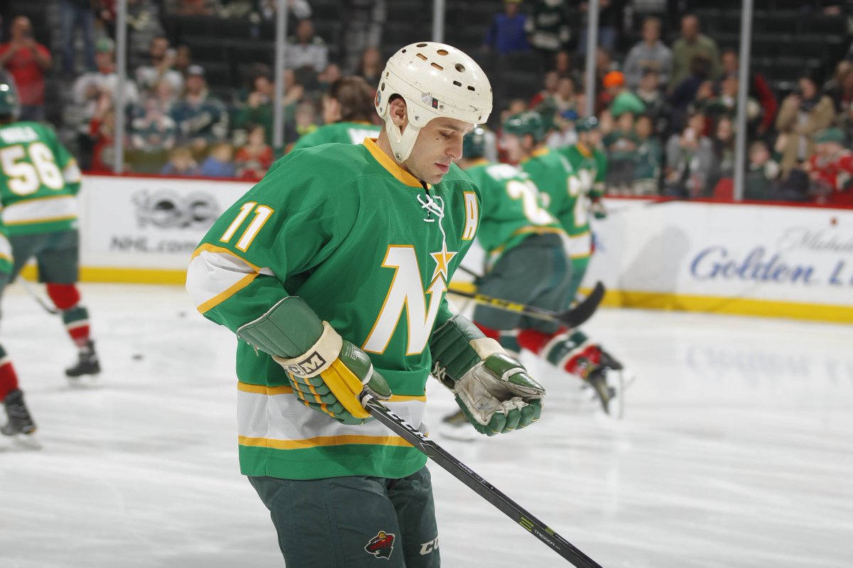 The Minnesota Wild's Zach Parise (11) wears his late father J.P.'s helmet  and gloves, as well as a North Stars jersey, during warmups before the  start of a game against the Carolina