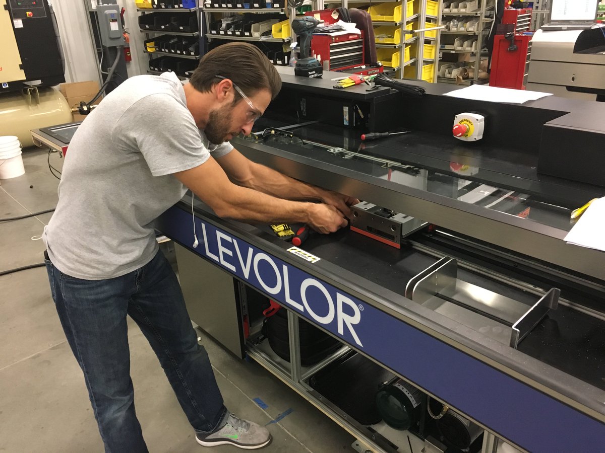 Michael is making final adjustments on a blind cutting machine. REI has installed over 600 machines in Lowe's stores in the US and Canada.