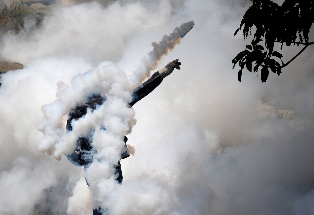 instantmatch's tweet image. A demonstrator throws back tear gas during the "mother of all marches" in Caracas, Venezuela April 19, 2017. @carlosrwalins @reuterspictures