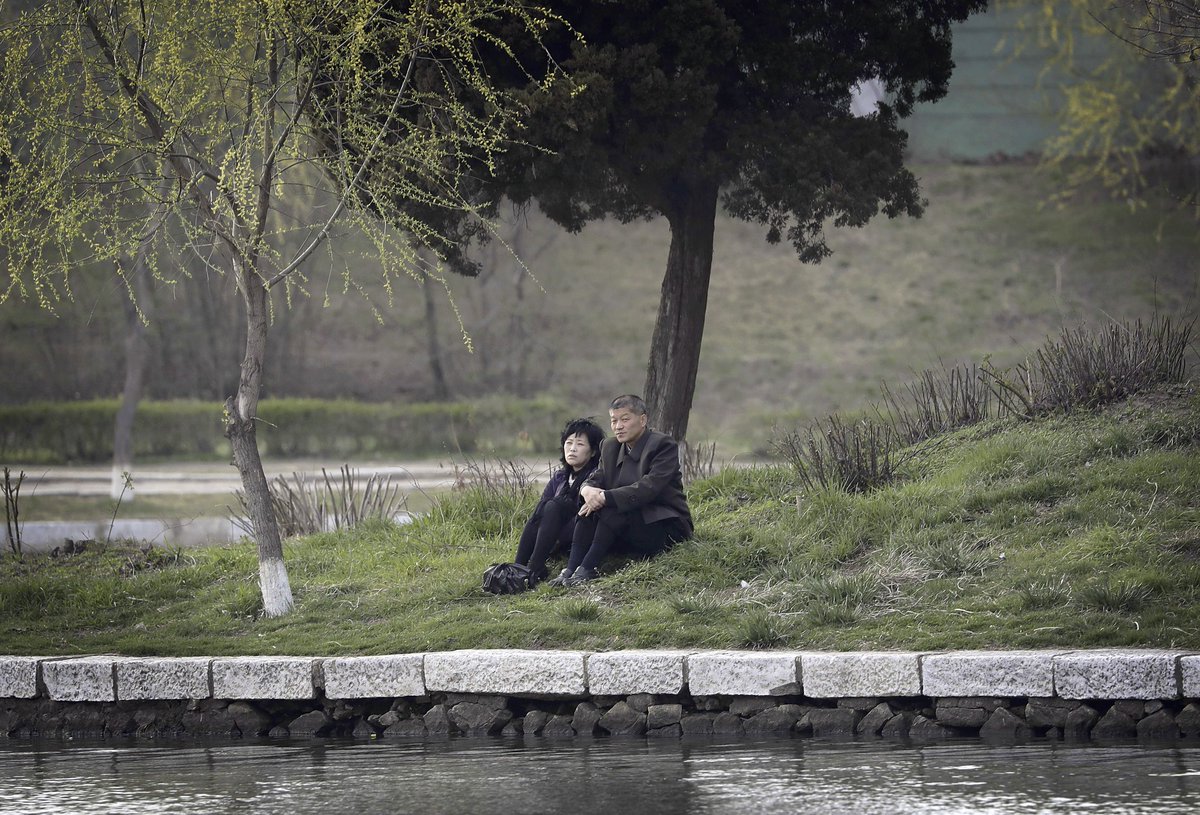 instantmatch's tweet image. A couple at the end of a work day, sits by the Pothong River in Pyongyang, North Korean capital, April 10, 2017 @mayersINsg @AP @AP_Images