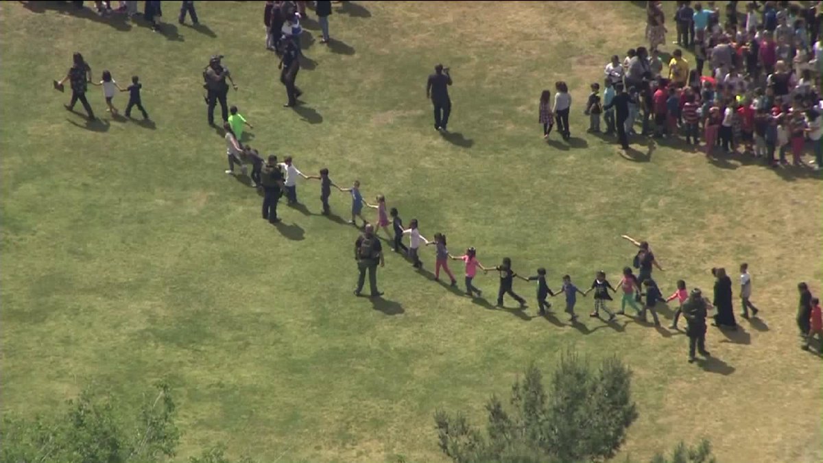 valeriegratias's tweet photo. BREAKING: Students hold hands while evacuating North Park Elem, in #SanBernardino after apparent murder-suicide on campus. 2 students hurt https://t.co/zvuALVuk6F