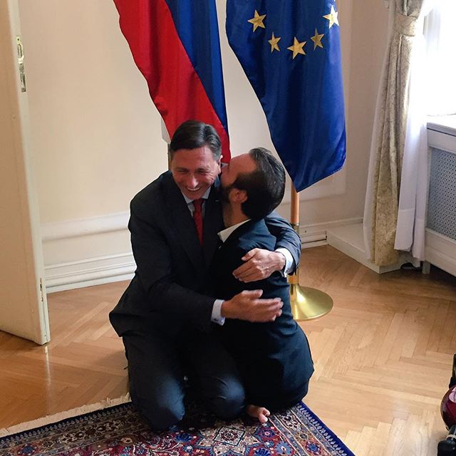 Slovenian President Borut Pahor on his knees, hugging motivational speaker Nick Vujicic, born with tetra-amelia without fully formed limbs.