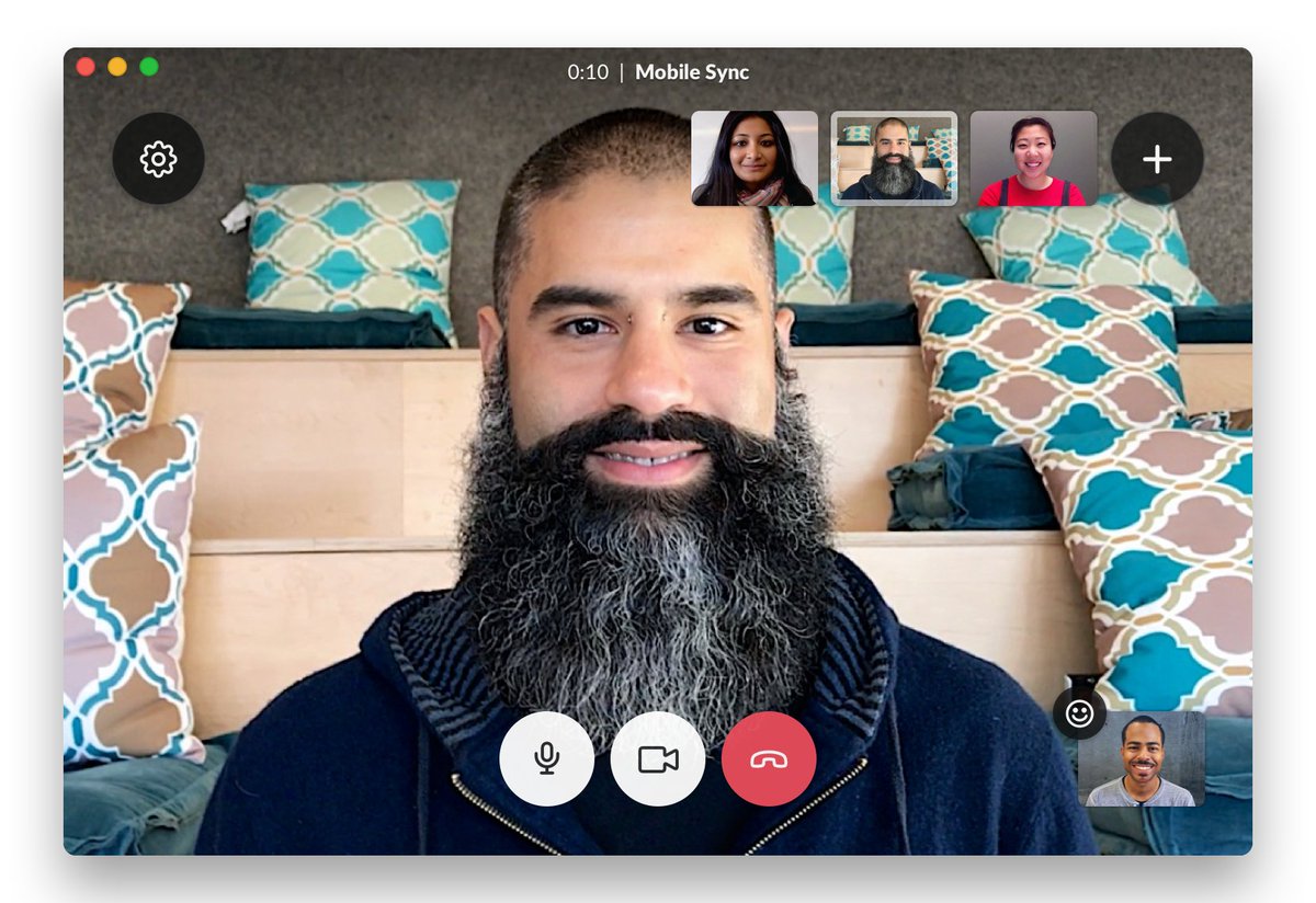 An image of a handsome gentleman with a beard sits resplendent in the center of our screengrab of people using Slack Video Calls. Some of the buttons bedecking on the screen have moved location, meaning that people now invite and share a call in the same place, and, in a revamp of the design, some previously square buttons are now well-rounded.