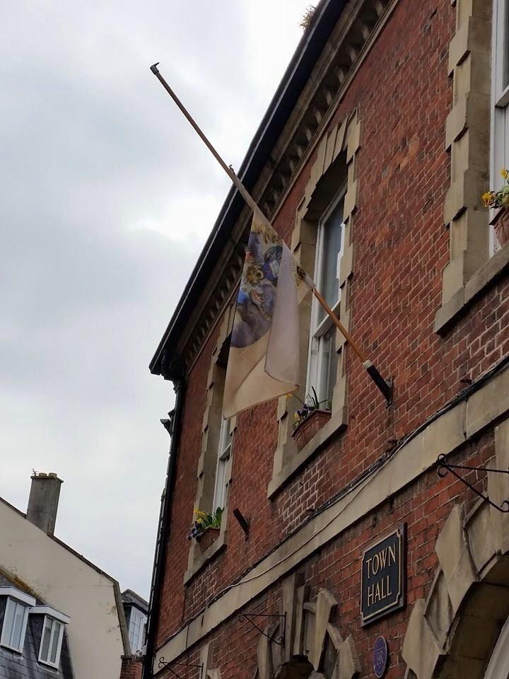 Discworldshoppe's tweet image. A little wind-whipped, the Ankh-Morpork flag flies at half mast in twin-town Wincanton...