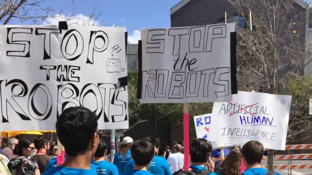 verge's tweet image. Humans protest potential robot overlords at SXSW theverge.com/e/7989270